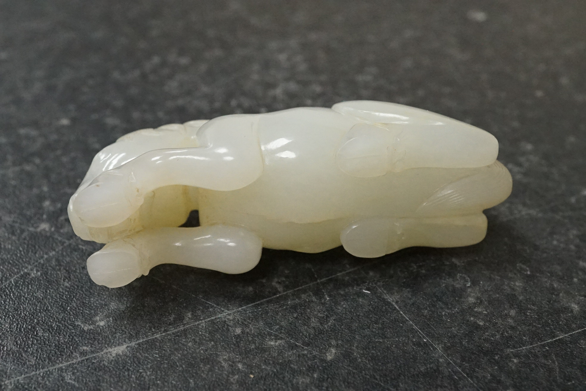 A Chinese white jade figure of a recumbent horse